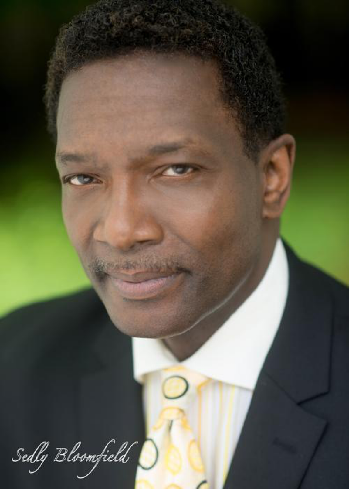 Sedly Bloomfield in a dark suit and patterned yellow tie